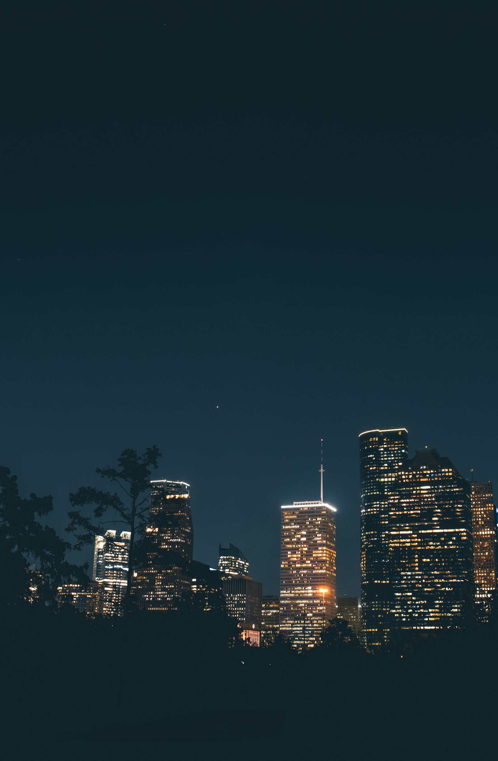 Houston skyline glowing at night beneath a dark sky