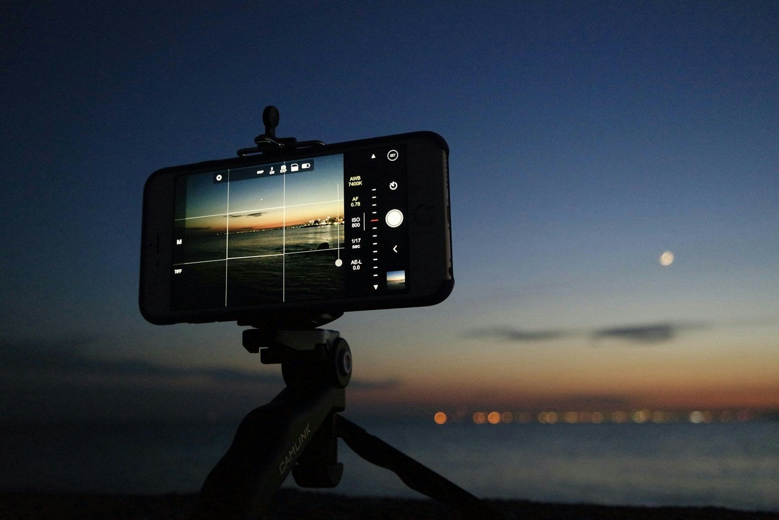Smartphone on tripod aimed at a colorful horizon after sunset.