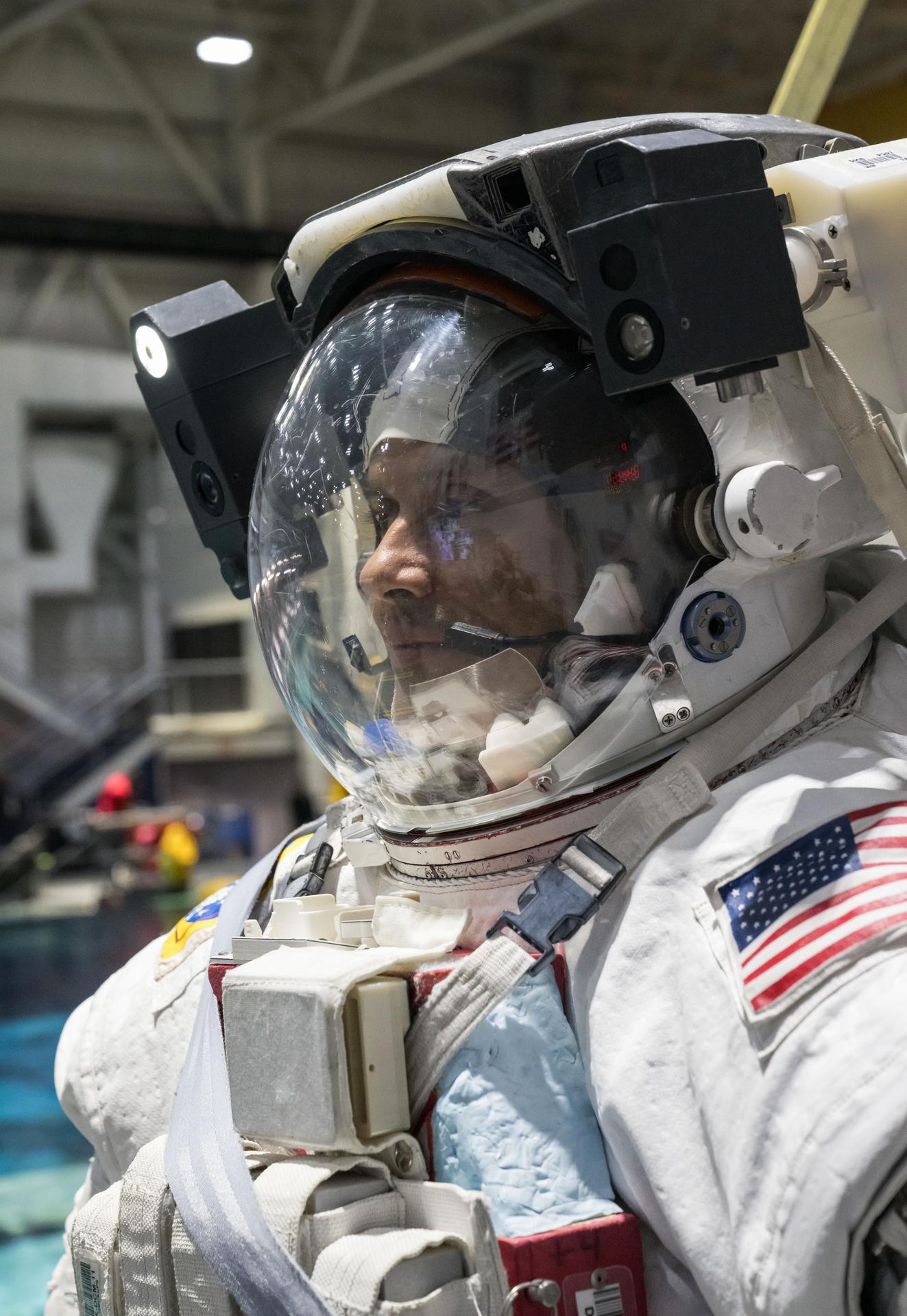 Astronaut preparing a spacesuit inside the International Space Station Quest airlock