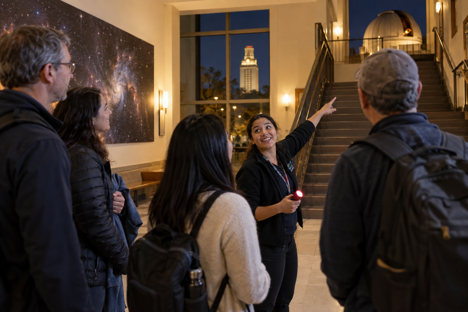 A university astronomy guide welcomes a small group of first-time visitors and points upstairs