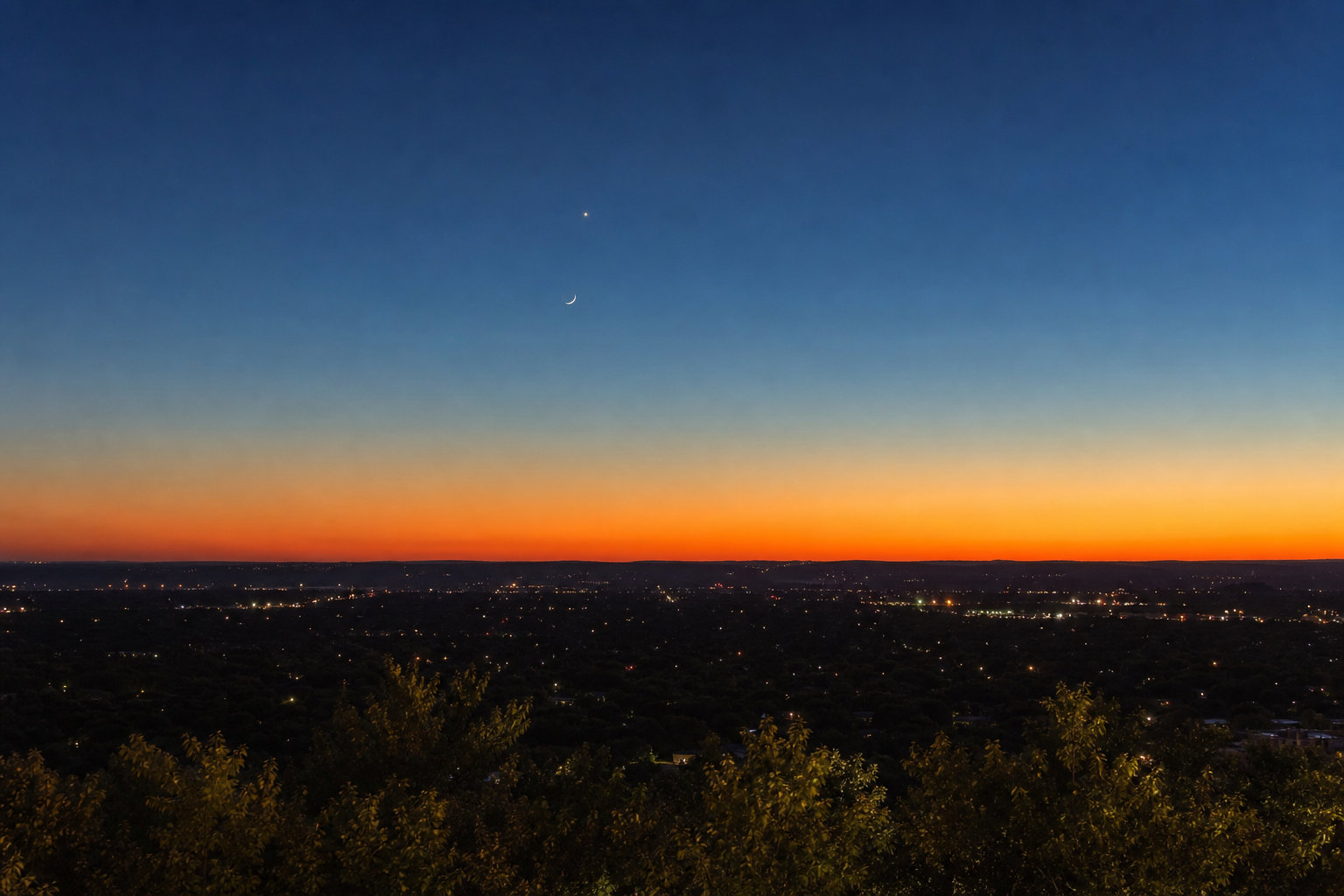 A clear western twilight horizon with the young Moon and Venus