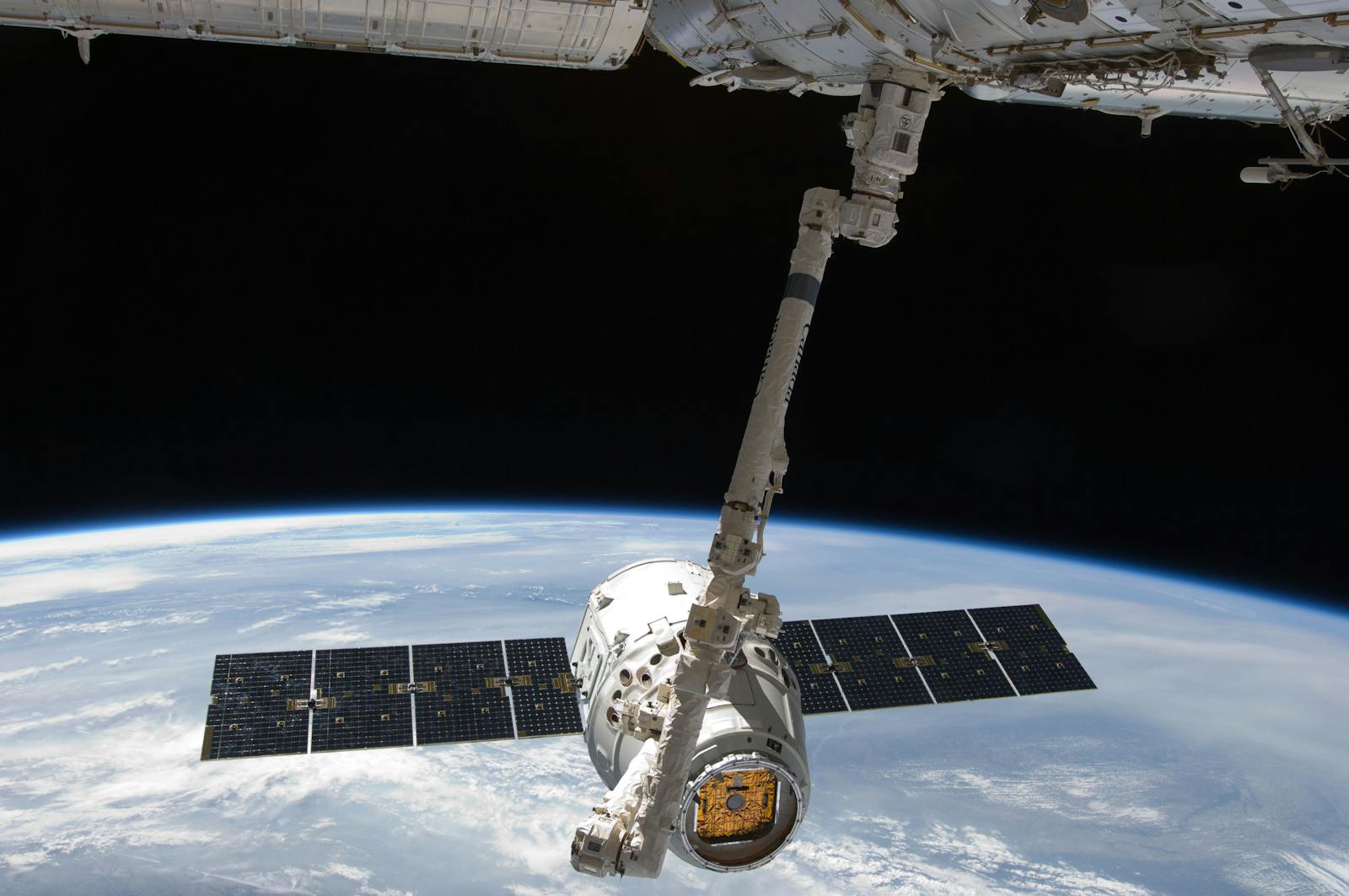 Dragon spacecraft docked near the ISS above Earth