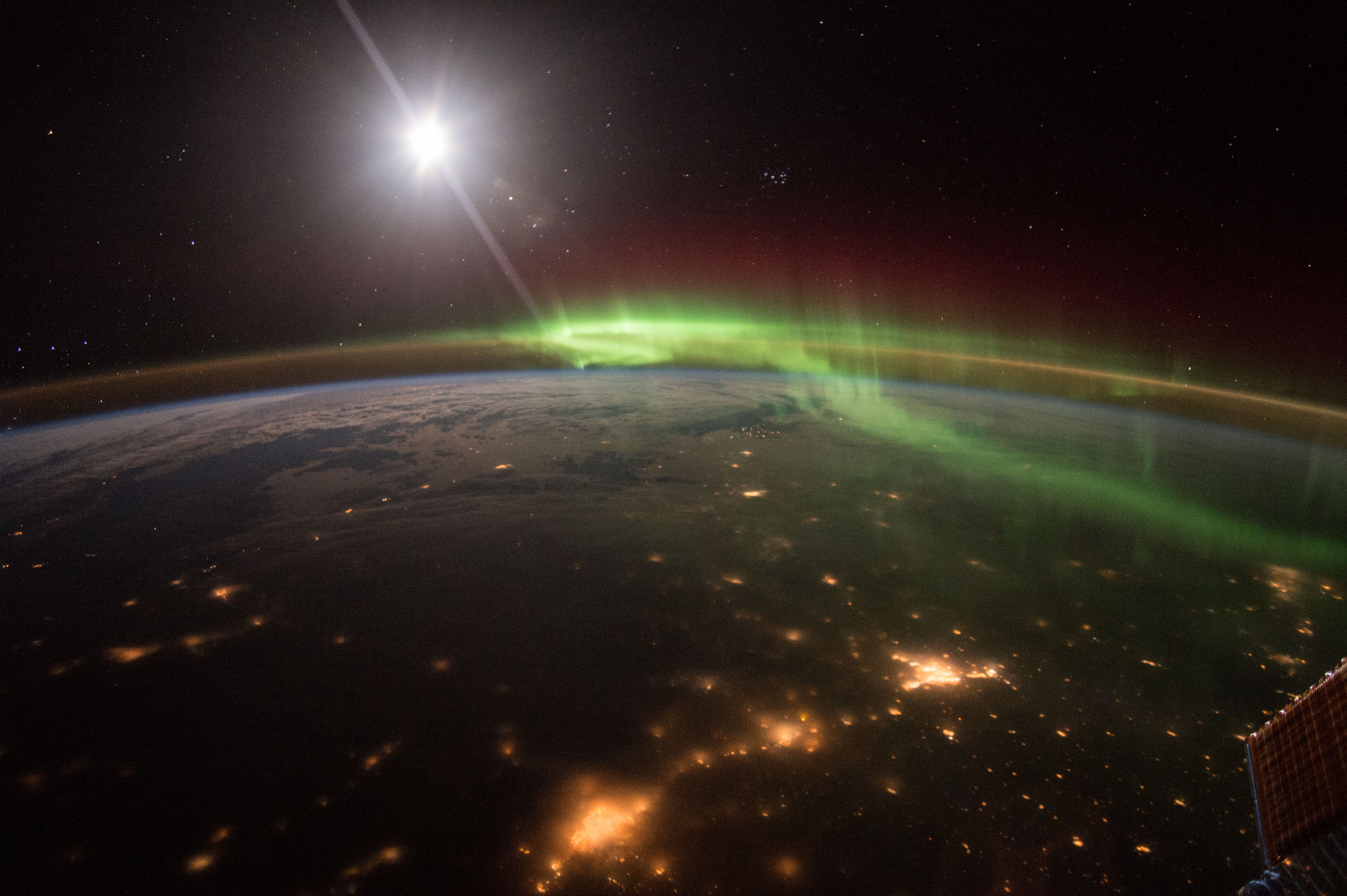 Aurora glowing above Earth from orbit