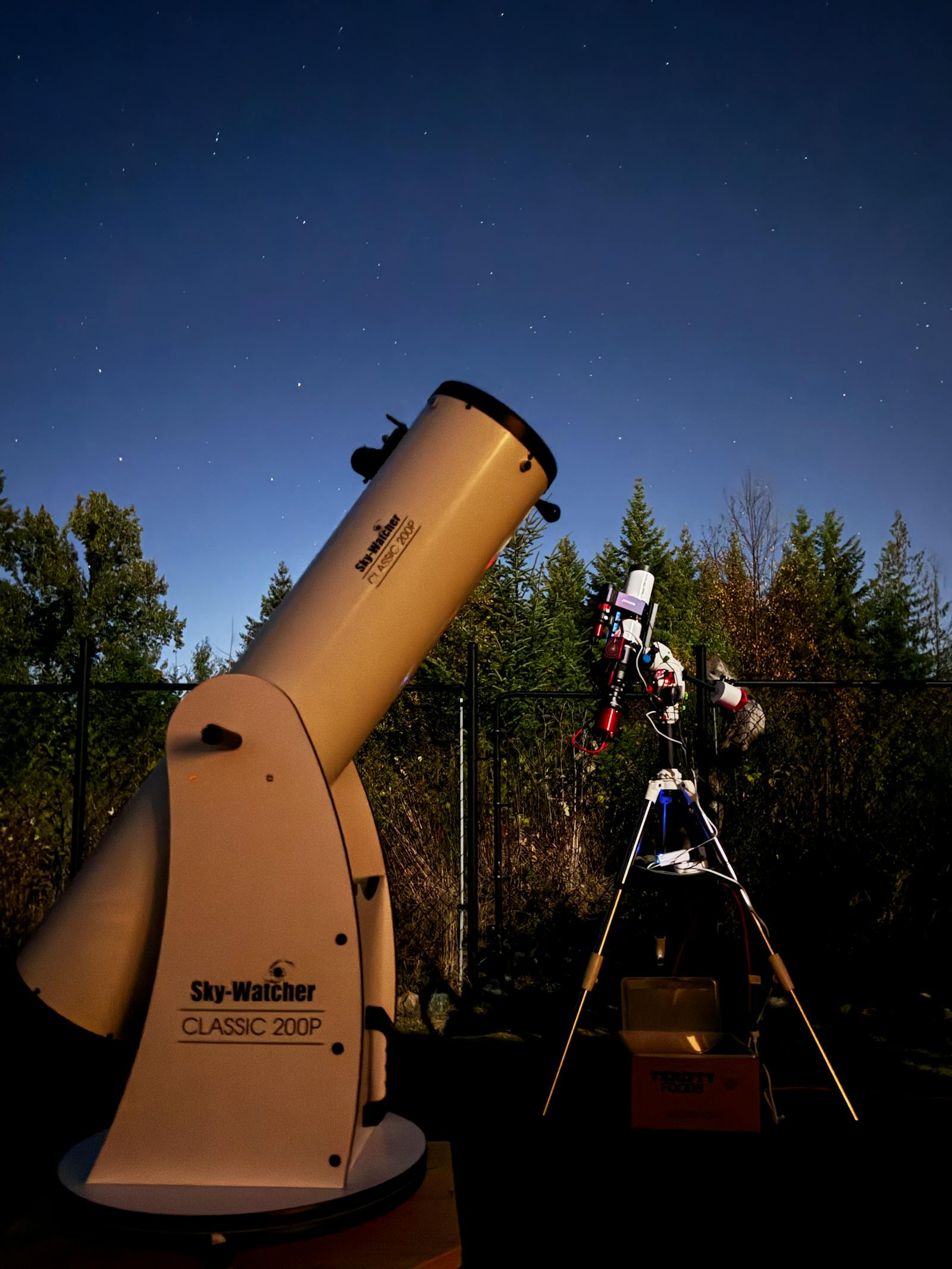 Large Dobsonian reflector telescope set up outdoors under a starry sky