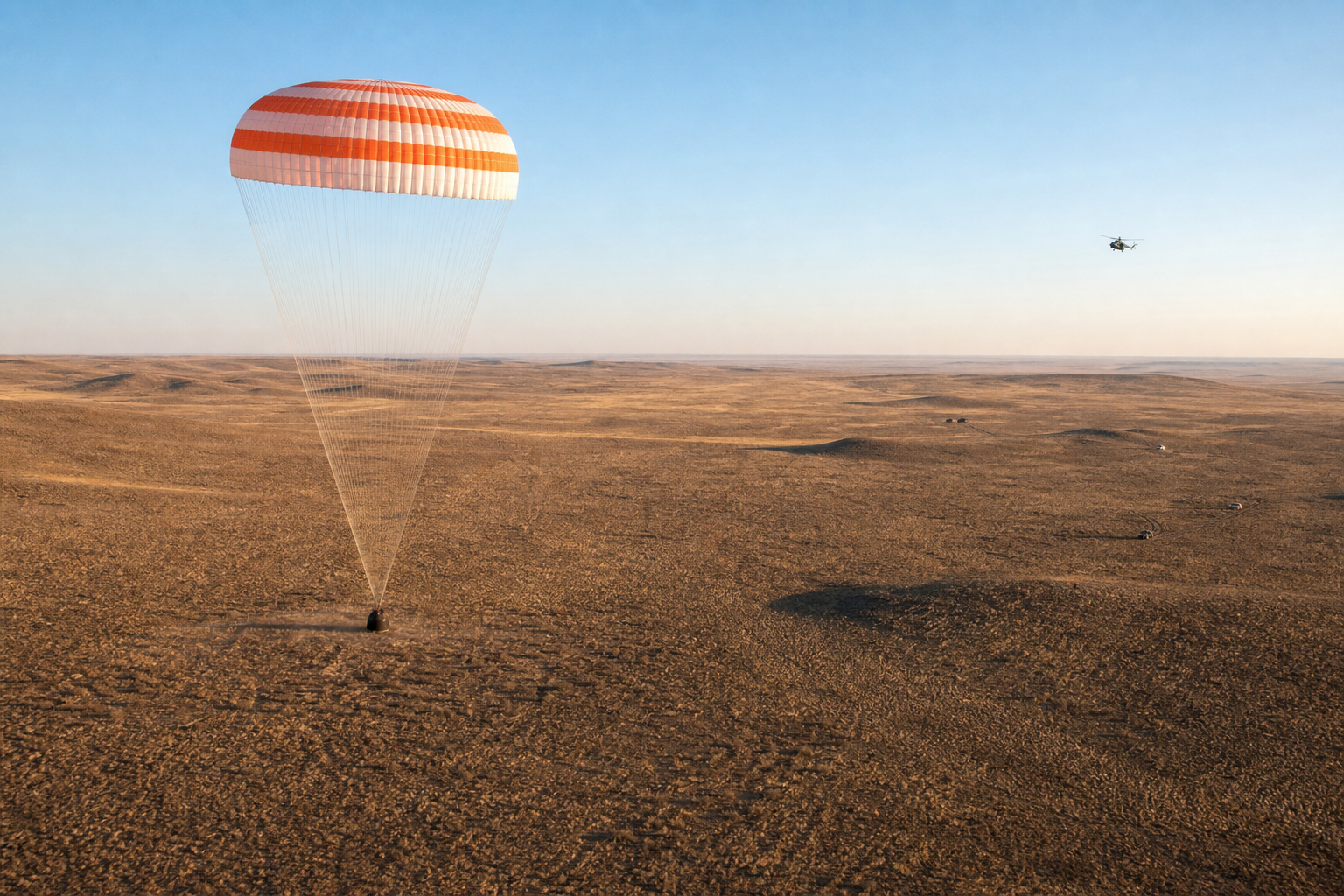 Soyuz-style capsule descending safely under an orange-and-white parachute over the Kazakh steppe