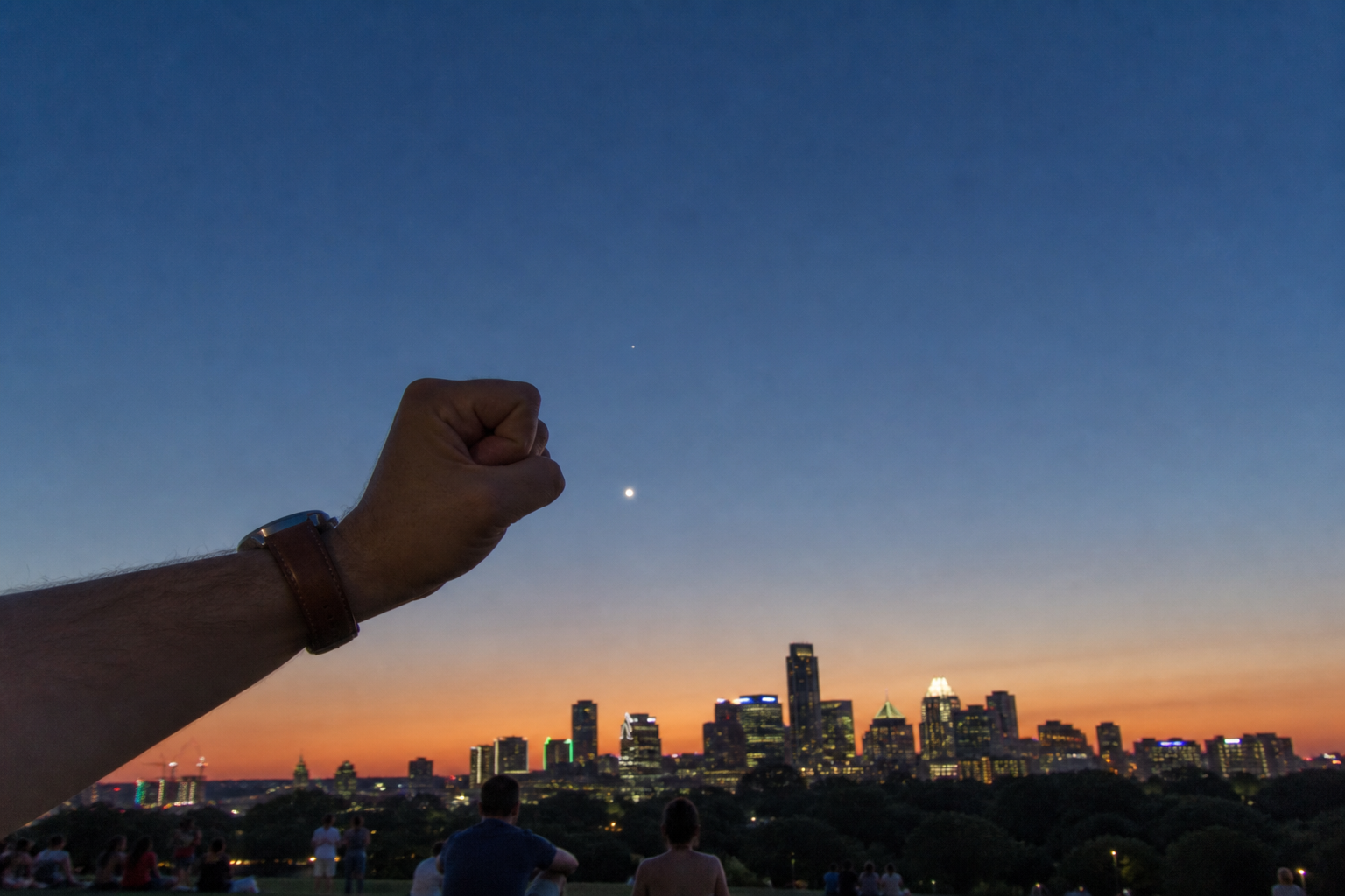A hand offers a simple fist-width scale beneath the twilight Venus–Spica pairing.