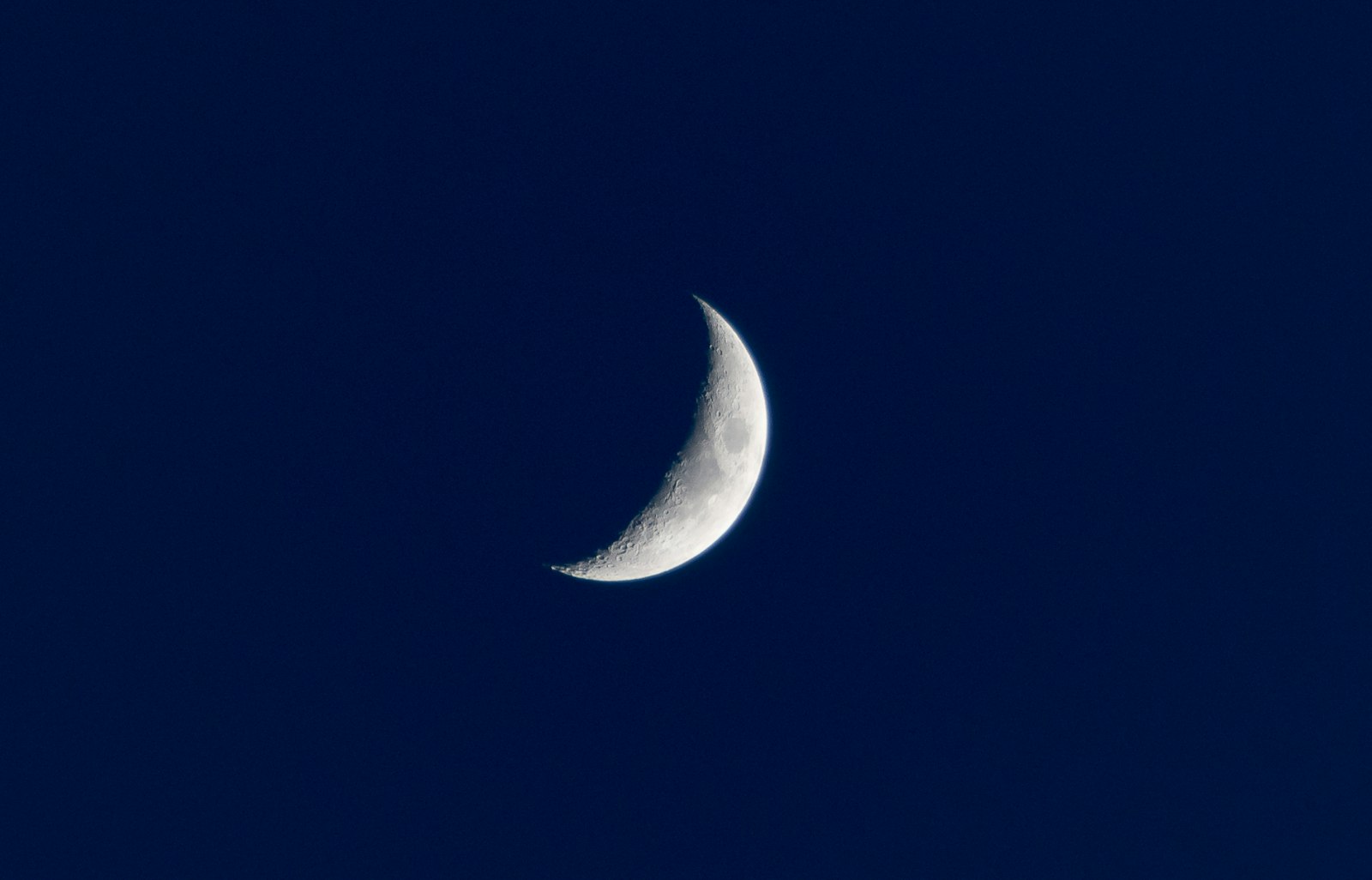 Crescent moon against a deep blue night sky